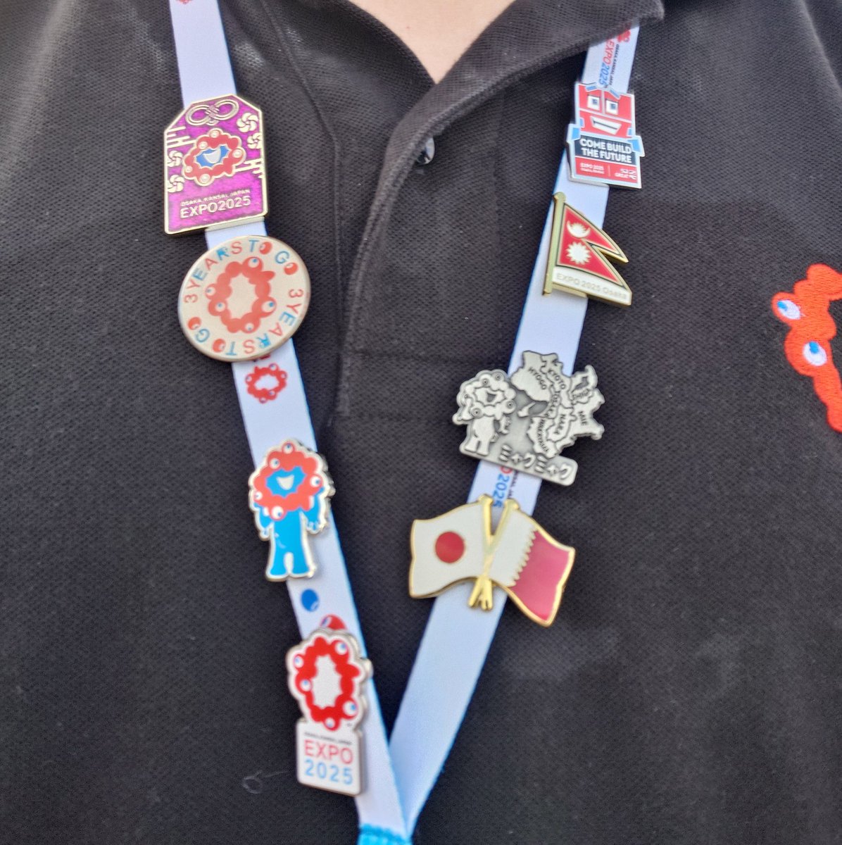 大まかですが、大阪関西万博関連のピンバッジをネックストラップに付け
