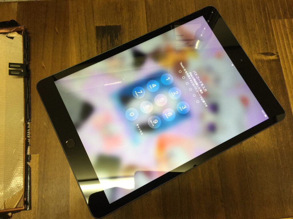 iPad 8 の画面が全体的にひび割れて破片が飛び散っている状態を